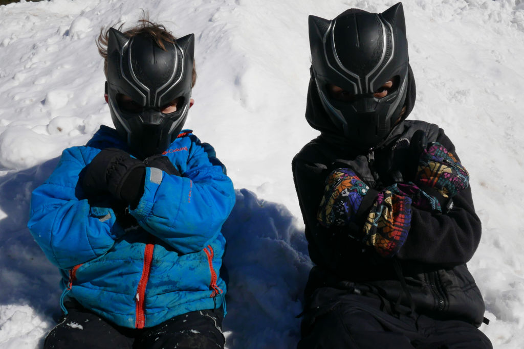 Two boys in Black Panther masks in the snow